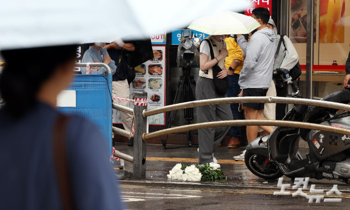 서울시청 인근 교차로 사고현장에 파손된 오토바이와 희생자를 추모하는 조화가 놓여 있다. 황진환 기자