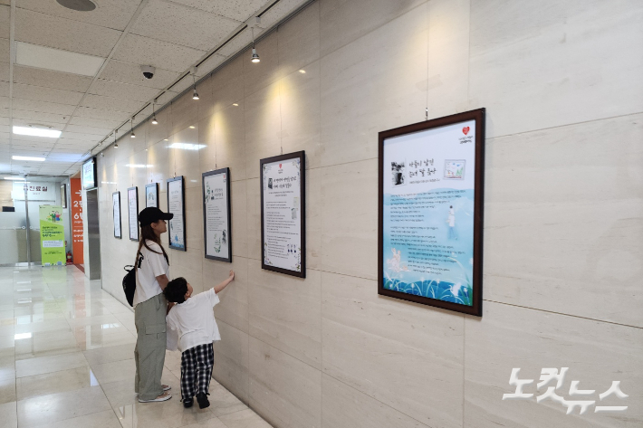 5일 전남대병원을 찾은 환자와 보호자가 1동 1층에 마련된 장기 기증 스토리를 관람 중이다. 박요진 기자