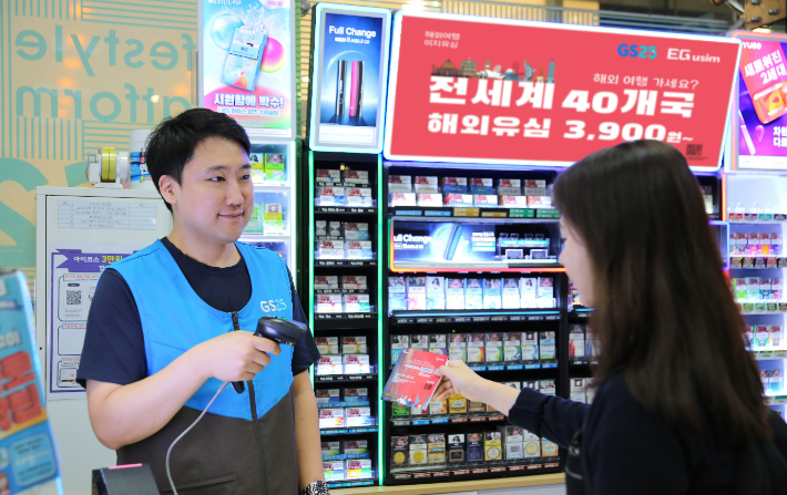 GS25에서 고객이 해외선불유심 '해외여행에는 이지유심'을 구매하고 있다. GS리테일 제공
