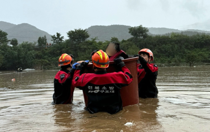 10일 오전 내린 폭우로 전북 완주군 운주면 한 마을 주민들이 고립돼 119구조대원들이 구조 작업을 벌이고 있다. 이날 주민 18명이 고립됐으나 모두 무사히 구조됐다. 연합뉴스