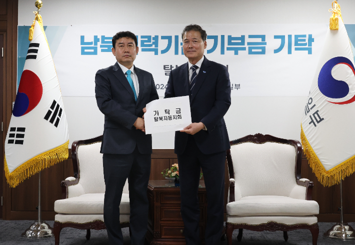 통일부 김영호 장관이 11일 서울 종로구 정부서울청사에서 열린 민간의 기부금을 남북협력기금에 적립가능 하도록 한 개정 '남북협력기금법'시행 이후 첫 기부금 전달식에서 서재평 탈북자동지회 회장으로부터 기탁금을 전달받고 있다. 연합뉴스