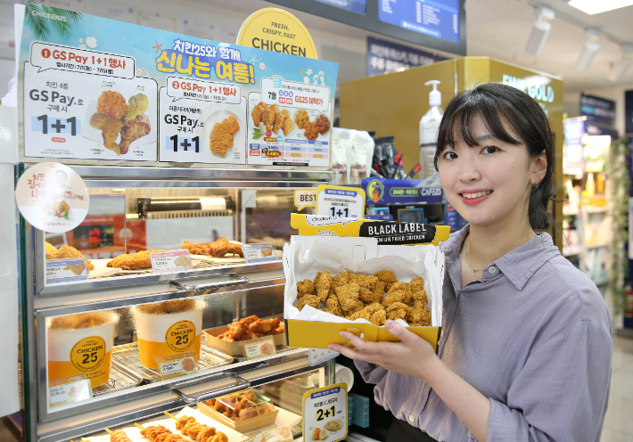 GS25에서 모델이 치킨25 뉴쏜살치킨을 들고 있다. GS25 제공