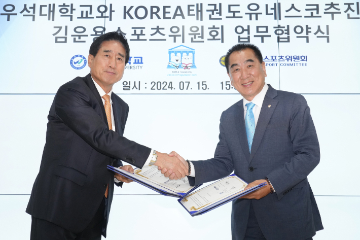 박노준 우석대 총장과 최재춘 KOREA 태권도 유네스코 추진단장이 지난 15일 업무협약식에서 악수하고 있다. 우석대 제공