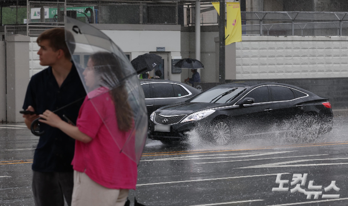 서울 광화문광장 인근에서 승용차들이 물보라를 일으키며 달리고 있다. 황진환 기자