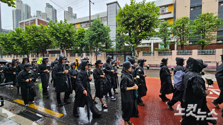 서이초 순직교사 1주기인 18일 서울 서초구 서울서이초등학교 앞에서 전국교직원노동조합 조합원 및 시민들이 국화꽃을 들고 국회 앞까지 추모행진을 하고 있다. 나채영 기자