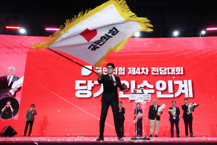 국민의힘 한동훈 신임 당대표가 23일 경기도 고양시 킨텍스에서 열린 국민의힘 제4차 전당대회에서 당기를 흔들고 있다. 연합뉴스