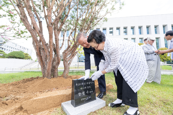 24일 전북대 장명수 전 총장의 1주기 추념식에서 장 전 총장의 미망인과 양오봉 총장이 고인의 추념비를 어루만지고 있다. 전북대 제공