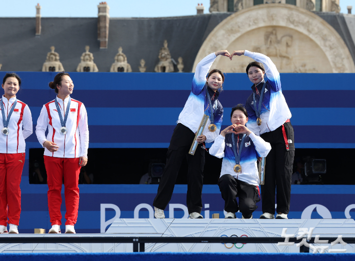 28일(현지시간) 프랑스 파리 앵발리드 경기장에서 열린 2024파리올림픽 양궁 여자 리커브 단체 결승 한국과 중국의 경기. 남수현, 전훈영, 임시현이 시상식에서 하트를 그려보이고 있다. 2024.7.28. 파리=올림픽사진공동취재단/JIN 황진환 기자