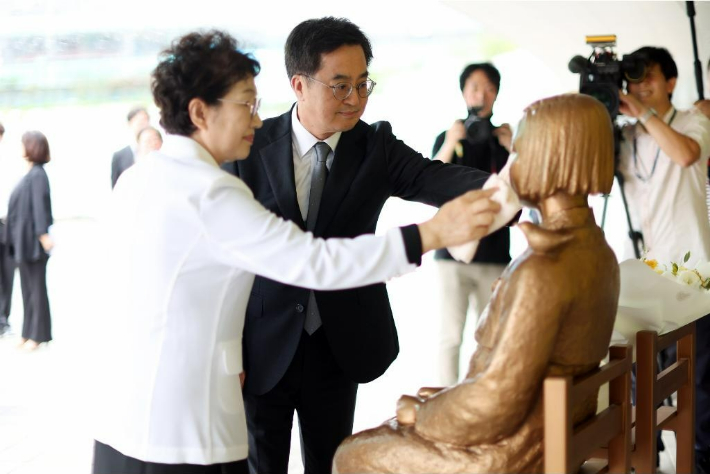 지난 24일 김동연 경기도지사가 전국의 139개 소녀상에 꽃을 배달하는 '기억의 꽃배달' 캠페인을 마무리하는 행사에 참석한 뒤 부인 정우영 여사와 함께 경기도청에 있는 소녀상의 얼굴을 닦아주고 있다. 경기도 제공