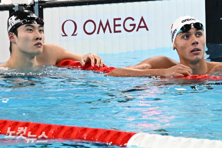 황선우가 지난달 28일 파리 라 데팡스 아레나에서 열린 2024 파리올림픽 수영 자유형 남자 200m 예선전 후  포포비치와 기록을 확인하고 있다. 올림픽사진공동취재단