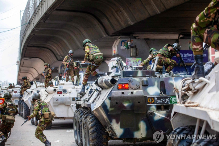 (다카 AFP=연합뉴스) 20일(현지시간) 방글라데시 수도 다카에서 군인들이 순찰하기 위해 장갑차에서 내리고 있다. 