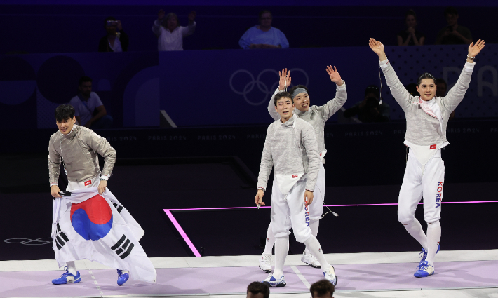  올림픽 3연패를 이룬 펜싱 사브르 남자단체 한국 대표팀 구본길(왼쪽부터), 도경동, 박상원, 오상욱이 31일(현지시간) 프랑스 파리 그랑 팔레에서 열린 2024 파리올림픽 펜싱 남자 사브르 단체 헝가리와의 결승에서 승리한 뒤 기뻐하고 있다. 연합뉴스