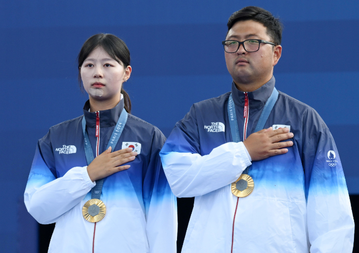 양궁 김우진과 임시현이 2일(현지시각) 프랑스 파리 앵발리드에서 열린 2024 파리 올림픽 양궁 혼성 단체 시상식에서 애국가 연주를 듣고 있다. 2024.8.2 파리=올림픽사진공동취재단 / ZU 파리=황진환 기자