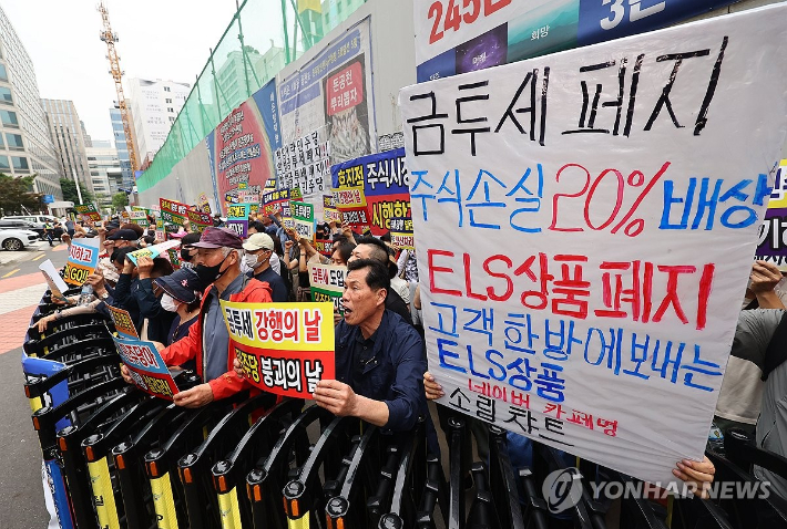 (서울=연합뉴스) 서대연 기자 = 한국주식투자자연합회(한투연) 회원들이 30일 오후 서울 영등포구 더불어민주당 당사 앞에서 금융투자소득세(금투세) 폐지 촉구 집회를 열고 구호를 외치고 있다. 2024.5.30 dwise@yna.co.kr 연합뉴스