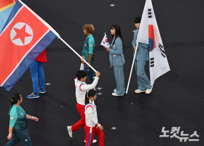 2024파리올림픽 폐회식이 열린 11일 프랑스 생드니 스타드 프랑스에서 태권도 박태준과 복싱 임애지가 대한민국 깃발을 들고 입장한 가운데 인공기를 든 북한 레슬링 리세웅, 다이빙 김미래와 마주치고 있다. 2024.8.11 생드니=올림픽사진공동취재단 / ZU 황진환 기자