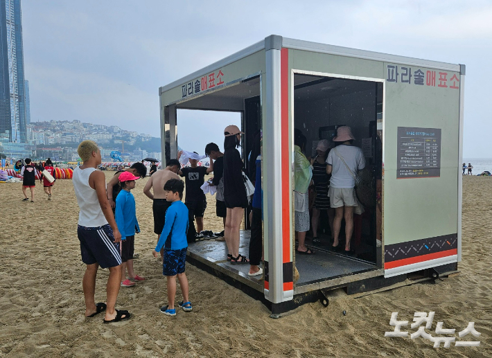 부산 해운대해수욕장 입구에 설치된 매표소에서 시민들이 피서용품을 직접 결제하고 있다. 김혜민 기자 