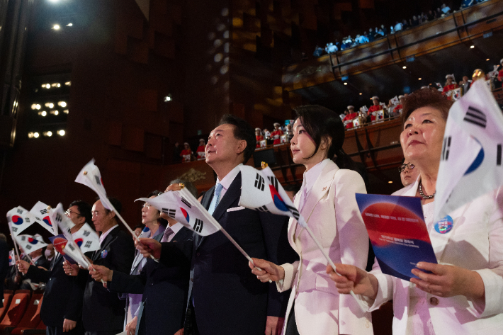 윤석열 대통령과 김건희 여사가 15일 서울 종로구 세종문화회관에서 열린 제79주년 광복절 경축식에서 태극기를 흔들고 있다.  연합뉴스