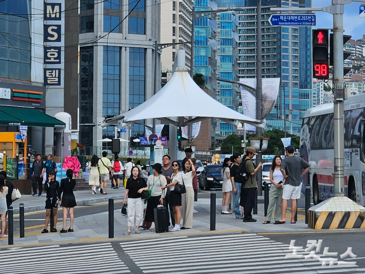 부산 해운대구의 한 도로에 설치된 그늘막 아래 시민들이 삼삼오오 모여 더위를 피하고 있다. 김혜민 기자 