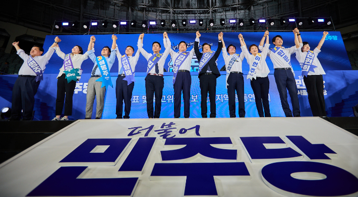 17일 오후 서울 중구 장충체육관에서 열린 더불어민주당 서울시당 제1차 정기전국당원대회 및 당대표·최고위원 후보자 합동연설회에서 당대표 및 최고위원 후보들이 손을 들어보이고 있다. 연합뉴스