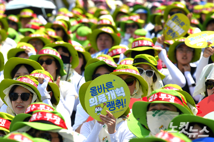 보건의료노조 조합원들이 지난 6월 12일 오후 서울 종로구 세종대로에서 총력투쟁 결의대회를 열고 적정인력 기준 제도화 및 주4일제, 공공의료 강화 등을 촉구하고 있다. 박종민 기자