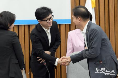 국민의힘 한동훈 대표가 29일 서울 여의도 국회에서 열린 딥페이크 성범죄 관련 부처 긴급 현안보고에 참석하며 김태규 방송통신위원장 직무대행과 악수를 하고 있다.