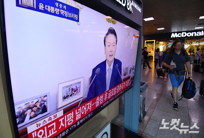 29일 오전 서울 용산구 서울역 대합실에서 시민들이 윤석열 대통령의 국정브리핑 생중계를 시청하고 있다. 류영주 기자