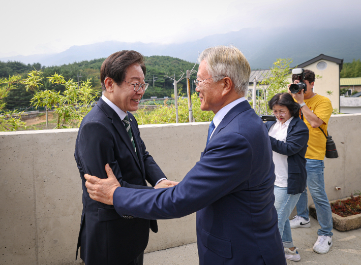 문재인 전 대통령이 8일 오후 경남 양산 평산마을 사저를 예방한 더불어민주당 이재명 대표(왼쪽)와 악수하고 있다. 더불어민주당 제공