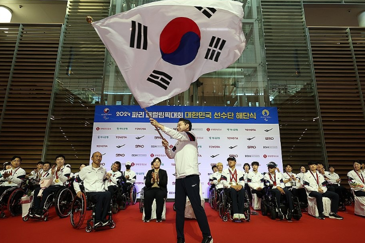 배동현 2024 파리 패럴림픽 선수단장이 10일 오후 인천국제공항 제2여객터미널에서 열린 2024 파리 패럴림픽 대한민국 선수단 해단식에서 단기를 흔들고 있다. 연합뉴스