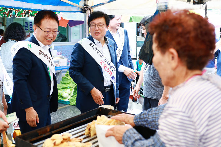 박형수 국회의원과 손병복 울진군수가 전통시장 장보기 행사를 갖고 있다. 울진군 제공