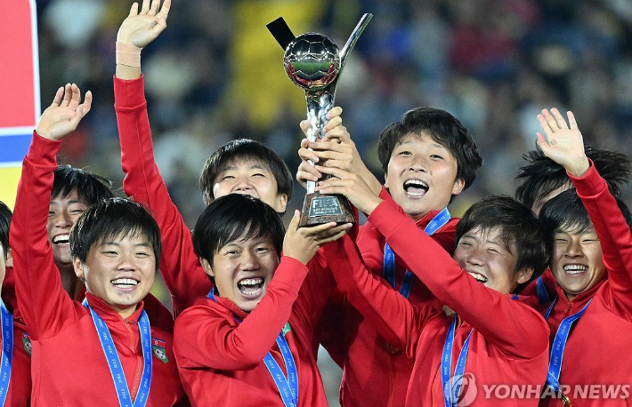 우승컵을 안고 기뻐하는 북한 여자 축구 선수들. 연합뉴스