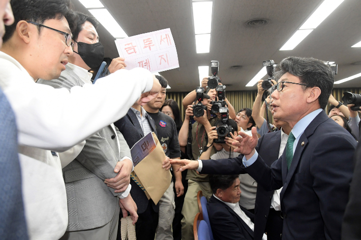 24일 서울 여의도 국회에서 열린 더불어민주당 정책 디베이트: '행복하고 정의로운 대한민국, 금융투자소득세 시행은 어떻게?' 정책의총에서 진성준 정책위의장이 토론회 참관을 요구하는 정의정 한국주식투자자연합회 대표 등 개인투자자들의 항의를 받고 있다. 윤창원 기자