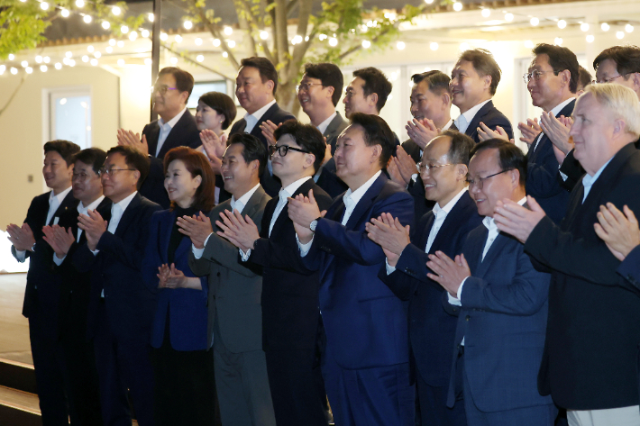 윤석열 대통령이 24일 서울 용산 대통령실 앞 분수정원에서 열린 국민의힘 지도부 초청 만찬 뒤 한동훈 대표, 추경호 원내대표 등 국민의힘 지도부, 대통령실 참모진과 함께 기념 촬영을 하고 있다. 대통령실 제공