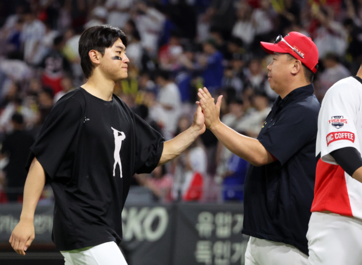 24일 광주 기아 챔피언스필드에서 열린 프로야구 삼성 라이온즈와 KIA 타이거즈의 경기. 7 대 1 낙승 뒤 KIA 김도영(왼쪽)이 이범호 감독과 하이파이브를 하고 있다. 연합뉴스