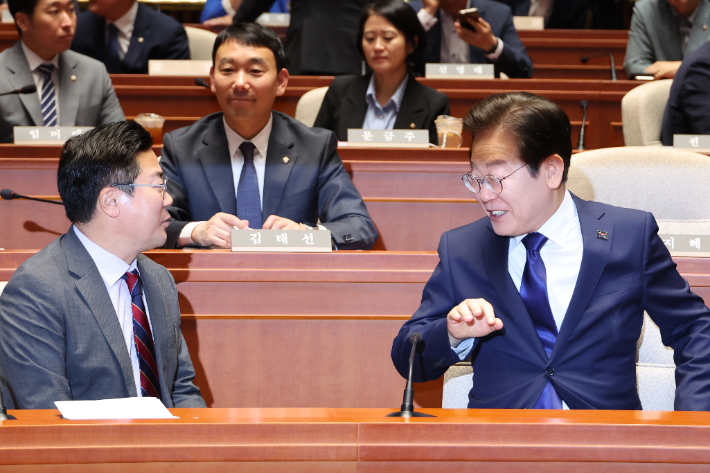 더불어민주당 이재명 대표와 박찬대 원내대표가 26일 오후 서울 여의도 국회에서 열린 의원총회에서 대화하고 있다. 연합뉴스