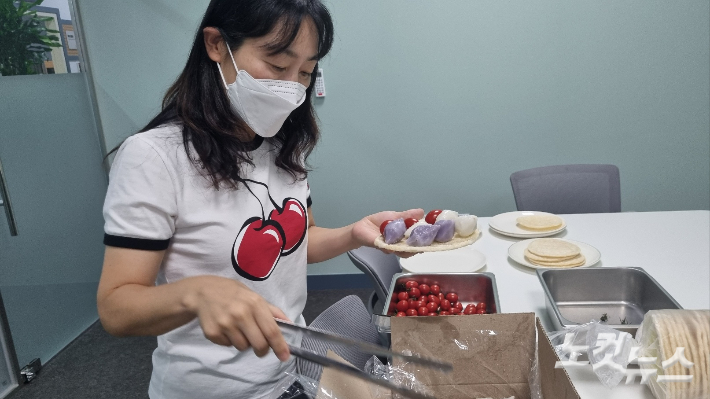 박성희씨가 26일 열린 생태학교에 참가해 뻥튀기 접시에 음식을 담고 있다. 박사라 기자 