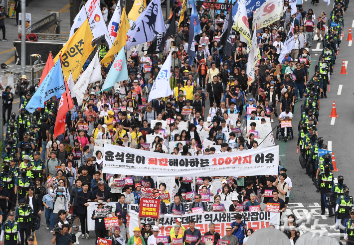 28일 오후 서울 중구 숭례문 앞에서 열린 '윤석열 정권 퇴진 시국대회' 참가자들이 용산 방향으로 행진하고 있다. 황진환 기자