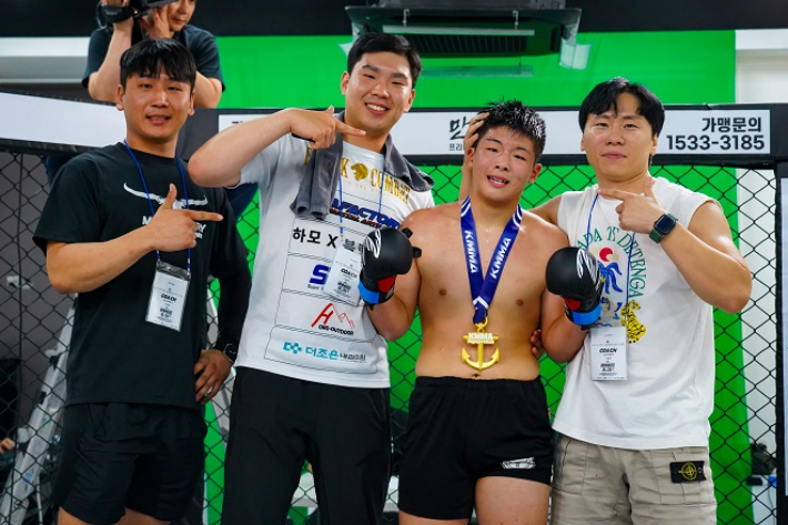 지난해 열린 'KMMA22'에서 페더급 랭킹 1위 한믿음(팀매드김해율하)을 꺾은 '중학생파이터' 김지후(사진 오른쪽에서 두 번째·MMA팩토리진주본관)가 기념 촬영을 하고 있다. 스탠다드앤드프로그레스 스포츠에이전시 제공