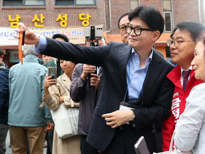 국민의힘 한동훈 대표가 6일 오전 부산 금정구 남산성당 앞에서 신도들과 사진을 찍으며 윤일현 금정구청장 보궐선거 후보 지지를 호소하고 있다. 연합뉴스