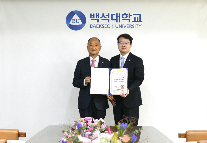 대통령 표창을 수상한 백석대 조정융 교수(오른쪽)가 장택현 대학혁신위원장에게 표창장을 전달받았다. 백석대 제공