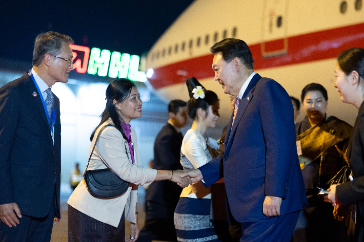 아세안 정상회의에 참석하는 윤석열 대통령과 김건희 여사가 9일(현지시간) 라오스 비엔티안 왓타이 국제공항에 도착해 영접 인사들과 악수하고 있다. 연합뉴스