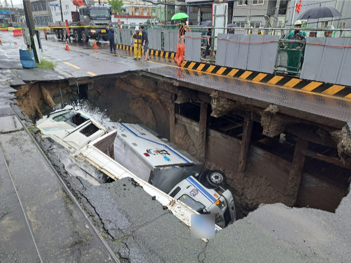 지난달 21일 부산 사상구 도시철도 사상~하단선 공사현장서 발생한 대형 땅꺼짐에 차량 2대가 빠졌다. 부산소방재난본부 제공