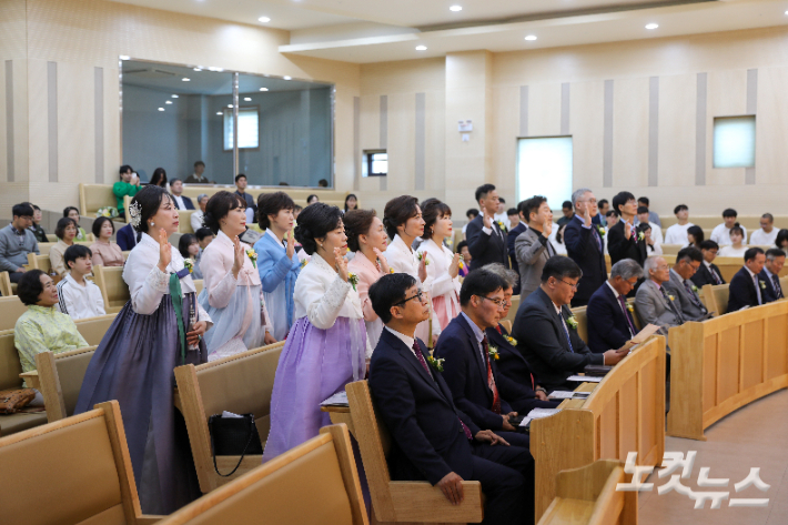 14명의 임직자들이 오른손을 들고 서약하고 있다.