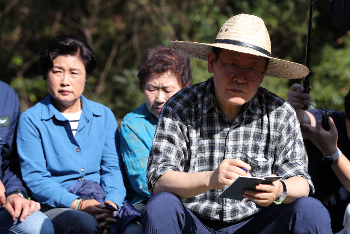 17일 오후 더불어민주당 이재명 대표가 강원 평창군 방림면 게촌리 배추밭을 찾아 농민들의 애로사항을 듣고 메모하고 있다. 연합뉴스