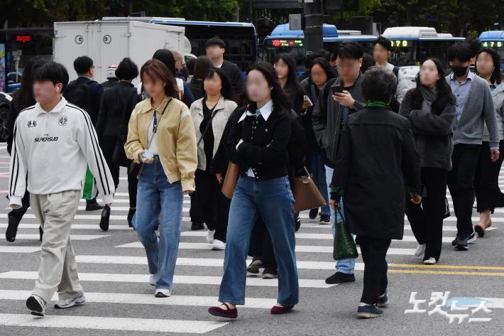 전국 대부분 지역의 아침 기온이 10도 안팎으로 떨어져 쌀쌀한 날씨를 보이는 21일 오전 서울 종로구 광화문네거리에서 시민들이 출근을 하고 있다.