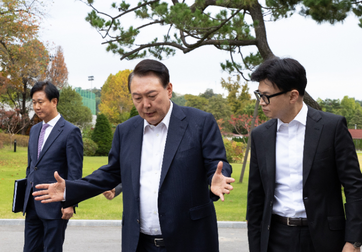 윤석열 대통령이 21일 서울 용산 대통령실에서 국민의힘 한동훈 대표를 만나 차담 장소인 파인그라스로 이동하며 대화하고 있다. 대통령실 제공