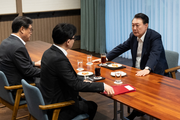 윤석열 대통령이 21일 서울 용산 대통령실 앞 파인그라스에서 국민의힘 한동훈 대표를 만나 대화하고 있다. 이 자리에는 정진석 대통령 비서실장이 배석했다. 대통령실 제공