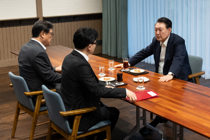 윤석열 대통령이 21일 서울 용산 대통령실 앞 파인그라스에서 국민의힘 한동훈 대표를 만나 대화하고 있다. 이 자리에는 정진석 대통령 비서실장이 배석했다. 대통령실 제공