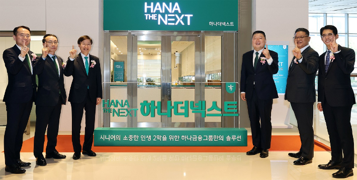 하나금융그룹은 지난 21일 그룹의 시니어 특화 브랜드 '하나 더 넥스트(HANA THE NEXT)'를 출범하고, 시니어 세대의 성공적인 노후를 위한 특화 서비스를 시행한다고 밝혔다. 이승열 하나은행장(사진 왼쪽에서 세 번째)과 '하나 더 넥스트'의 광고모델 방송인 강호동(사진 오른쪽에서 세 번째)이 하나은행 임직원과 함께 그룹 시니어 특화 브랜드 '하나 더 넥스트'의 출범을 알리는 현판식 진행 후 기념 촬영을 하고 있다. 하나금융그룹 제공