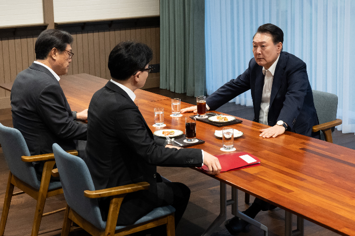 윤석열 대통령이 21일 서울 용산 대통령실 앞 파인그라스에서 국민의힘 한동훈 대표를 만나 대화하고 있다. 이 자리에는 정진석 대통령 비서실장이 배석했다. 대통령실 제공