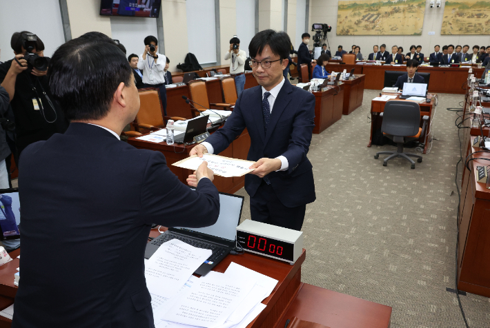 22일 국회에서 열린 교육위원회의 서울시교육청 등에 대한 국정감사에서 김영호 위원장이 담당 직원에게 국감에 불출석한 설민신 한경대 교수 고발장을 전달하고 있다. 연합뉴스